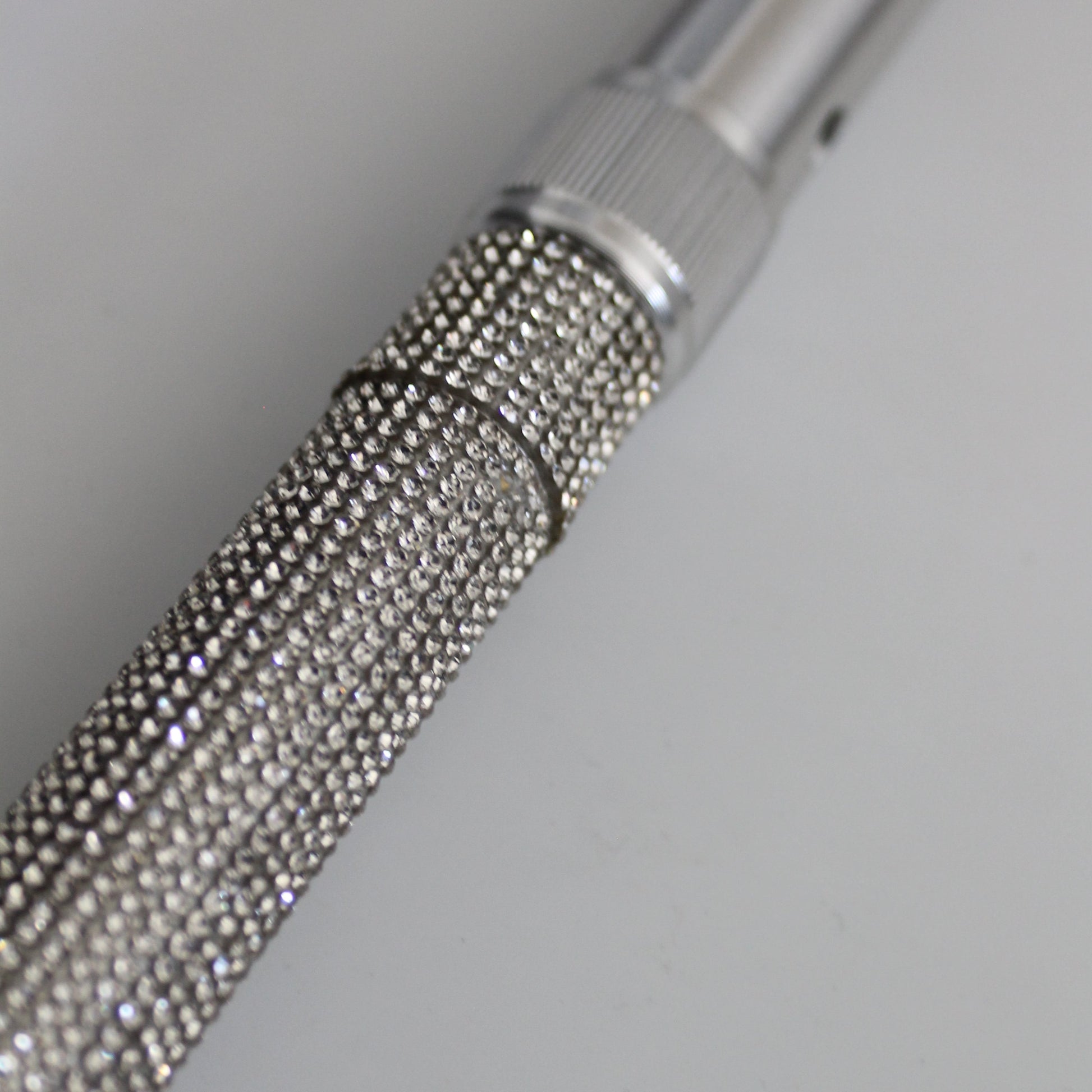 Metallic textured rod on a light gray background