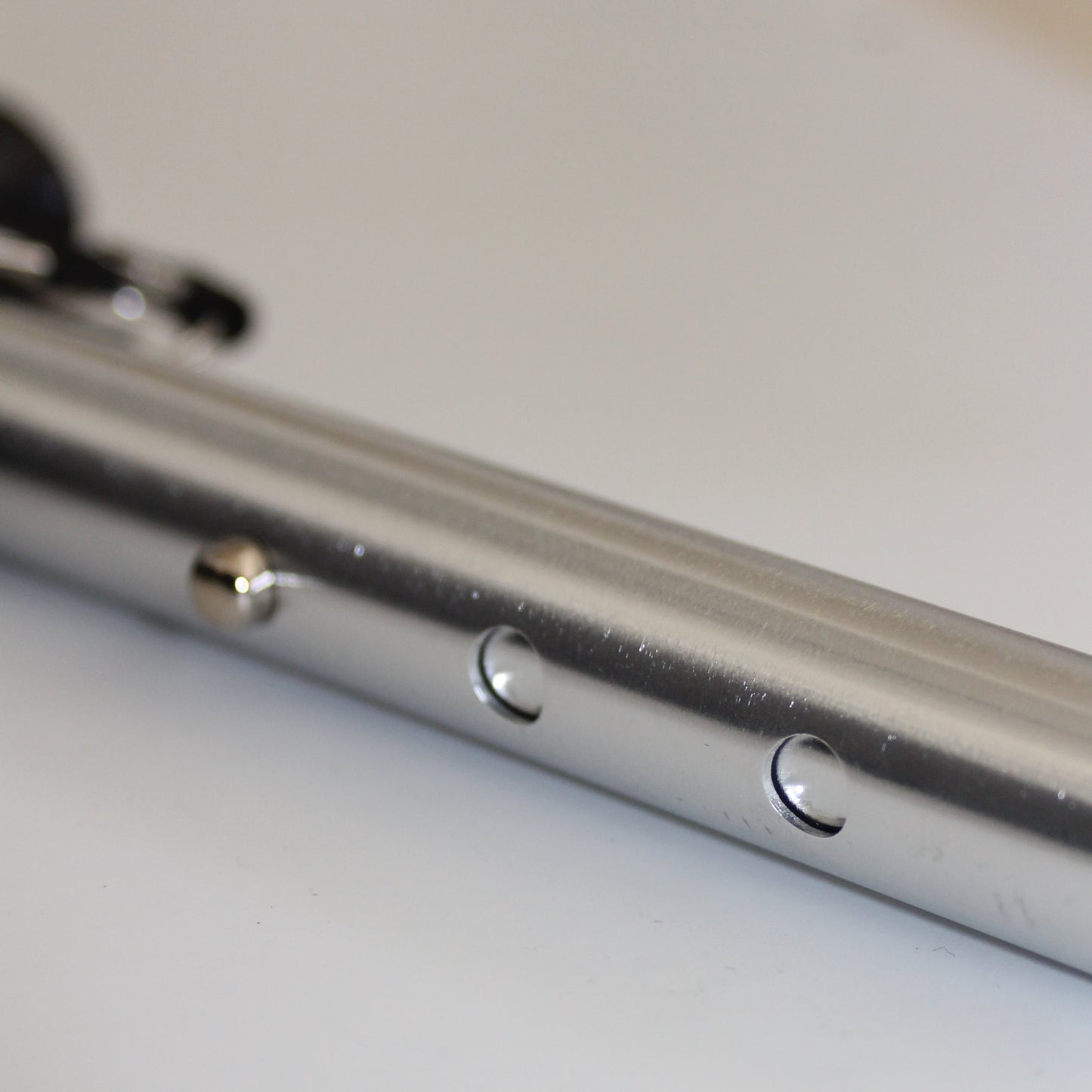 Close-up of a metallic object with screws on a white background